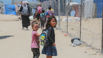 Displaced Palestinian children look on as people evacuate the Mawassi area on the outskirts of Khan Younis in the southern Gaza Strip on June 28, 2024. AFP