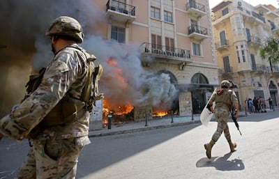 Lebanese soldiers clear the road next to a bank branch set ablaze by protesters in Tripoli in 2020. AFP