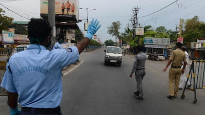 Police personnel and civic volunteers stop a vehicle at a checkpoint during a government-imposed nationwide lockdown in Siliguri. AFP