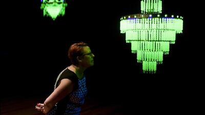 A visitor takes a look at a chandeliers made from ‘uranium glass’, which forms part of ‘The Last Temptation’ exhibition by artist Ken and Julia Yonetani at the National Gallery of Australia in Canberra. Lukas Coch / EPA