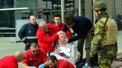 A victim receives first aid by rescuers, near Maalbeek metro station in Brussels, after a blast at this station near the EU institutions caused deaths and injuries. Emmanuel Dunand / AFP