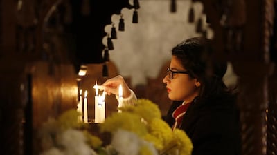 A Palestinian Christian woman lights a votive candle during Orthodox Christmas celebrations at the Saint Porphyrios Greek Orthodox church in Gaza City. Mohammed Abed / AFP Photo