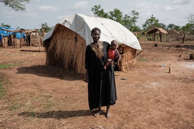 A woman poses for a photo outside her hut at the Tiamushro camp for internally displaced people in Kadugli, South Kordofan state. AFP