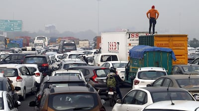 In this photo taken on December 19, 2019 a man stands on a truck to look at a huge traffic jam on the highway towards New Delhi on the outskirts of Gurgaon, as police set up roadblocks on the Haryana state border amid demonstrations against India's new citizenship law. Indians defied bans on assembly on December 19 in cities nationwide as anger swells against a citizenship law seen as discriminatory against Muslims, following days of protests, clashes and riots that have left six dead. AFP