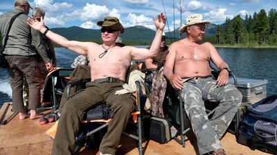 Russian President Vladimir Putin, left, and Defense Minister Sergei Shoigu rest after fishing during a mini-break in the Siberian Tyva region. Alexei Nikolsky / Sputnik, Kremlin Pool Photo via AP.