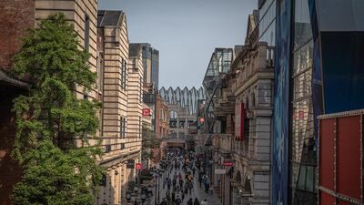 People wearing protective face masks walk at a shopping area in Wuhan, China, April 6, 2020. EPA