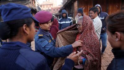 An elderly voter is checked by security before she enters polling statio in Thimi. Niranjan Shrestha / AP Photo