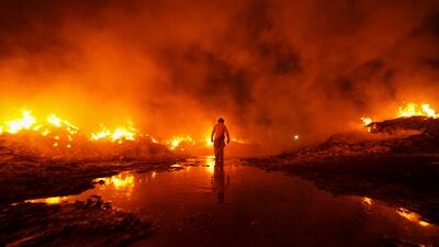 A firefighter battles a blaze at a cardboard recycling plant during a 12-hour operation in Mexicali, Baja California, Mexico. Reuters