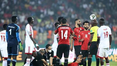 Egypt forward Omar Marmoush lies on the pitch, surrounded by teammates. AFP