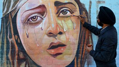 An artist paints a mural during a competition in Amritsar, India. AFP