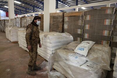 A Syrian rebel fighter stands near raw materials at the Captagon factory in Douma. EPA