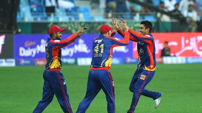 Karachi Kings players celebrate the dismissal of a Lahore Qalandars batsman.