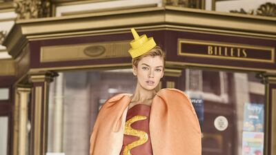 Moschino Spring/Resort 2022 offered a hotdog drress, with cape and mustard bottle cap hat. Courtesy Moschino