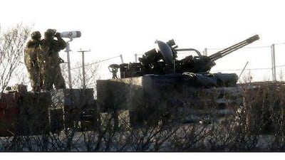South Korean marines next to an anti-aircraft gun on Yeonpyeong island yesterday look towards the North.