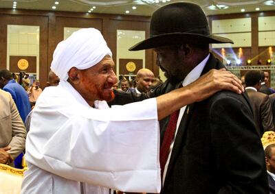 Sudan's veteran opposition leader Sadiq Al Mahdi pats the shoulder of South Sudan President Salva Kiir Mayardit in the capital Khartoum on August 17, 2019. AFP