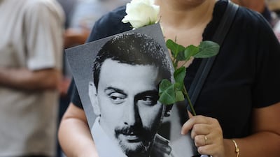 A mourner holds a portrait of Lebanese musician, composer and playwright Ziad Rahbani, as crowds gathered outside Khoury Hospital in Beirut's central Hamra district ahead of his funeral procession. AFP