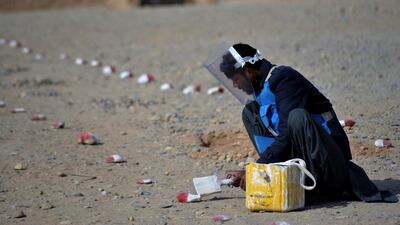 A deminer from the Hazardous Area Life-Support Organisation Trust paints stones to mark a cleared area in Afghanistan's Helmand province. AFP