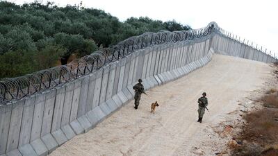 A K9 unit patrol along a wall on the border line between Turkey and Syria, near the southeastern village of Besarslan, in Hatay province, Turkey. Umit Bektas / Reuters