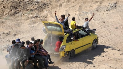 A car towing a cart with passengers moves along a dirt road to Gaza city. AFP