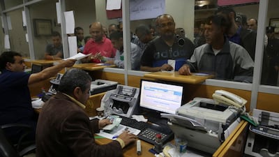 Palestinian Hamas government employees queue to receive 60 per cent of their long-overdue salaries at the main Gaza Post Office, in Gaza City, Friday, Nov. 9, 2018. AP