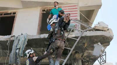 Syrian civil defence volunteers evacuate people from a damaged building following an air strike on the rebel-held neighbourhood of Tariq Al Bab in the northern city of Aleppo on April 23, 2016. Ameer Alhalbi / AFP