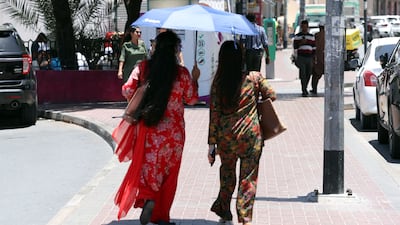 People take shelter from the sun on a hot day in Bur Dubai. Chris Whiteoak / The National