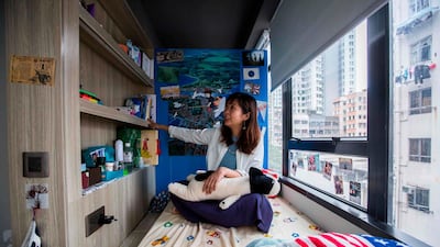Jezz Ng sits on her bed where she rents a small living space in a co-sharing building in the Mong Kok district of Hong Kong. As housing prices spiral in Hong Kong, young professionals are living in ever-shrinking spaces. Isaac Lawrence / AFP