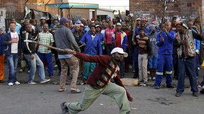 A local man gestures with a stick outside a hostel during the anti-immigrant violence in Johannesburg on April 17, 2015. Siphiwe Sibeko/Reuters