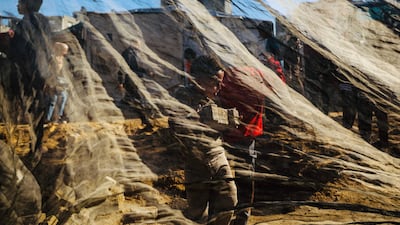 A child carries a block to help municipal workers repair a damaged road at Nuseirat camp for displaced Palestinians in the central Gaza Strip. AFP