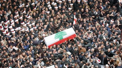 Draped with the Lebanese national flag, the coffin of assassinated former Lebanese prime minister Rafik Hariri is carried through a crowd in central Beirut in February 2005. EPA