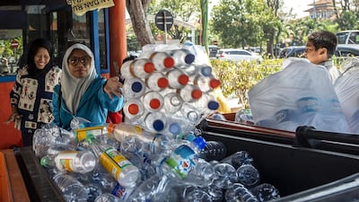 Commuters exchange plastic bottles for Suroboyo bus tickets at a terminal.