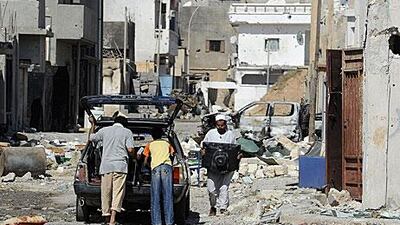 Libyans pack their belongings into a car in a damaged neighbourhood in Sirte in October.