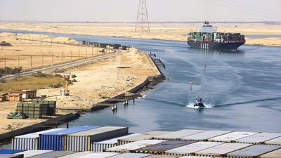 A Suez Canal Authority pilot vessel, centre, navigates a convoy of container ships as they pass southbound along the Suez Canal in Egypt. Kristian Helgesen / Bloomberg News