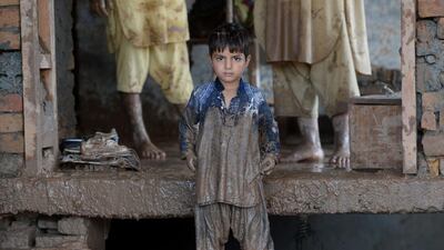 A Pakistani child looks on as his family cleans their home following flooding in Rawalpindi on September 6, 2014. Farooq Naeem/AFP Photo