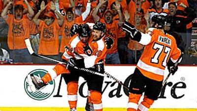 Mike Richards (18) of the Philadelphia Flyers celebrates with teammates Ryan Parent (77) and Claude Giroux (28) after scoring a goal in the first period.