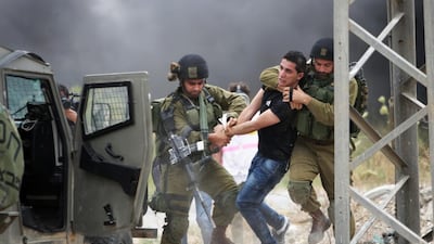 Israeli soldiers detain a protester during a demonstration by Palestinians protesting against the Israeli-built West Bank separation barrier and calling for the right of return for Palestinian refugees, in the northern West Bank city of Tulkarem on May 31, 2014. Nasser Ishtayeh/AP Photo