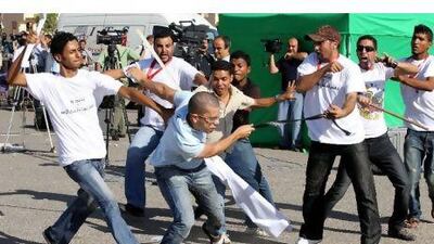 Supporters of former president Hosni Mubarak clash with an anti-Mubarak protester (centre) outside the court in Cairo yesterday. Khaled Elfiqi / EPA