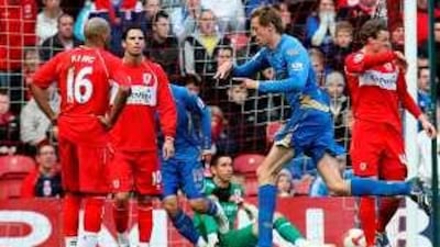 Portsmouth's Peter Crouch, second right, celebrates after scoring as Middlesbrough's players look on dejected.