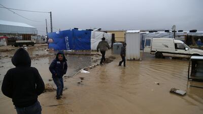 Syrian refugee boys walk near flooded tents in Bar Elias town, in the Bekaa valley. Reuters