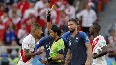 Referee Mohammed Abdulla Mohamed from the United Arab Emirates, second left, shows the yellow card to Peru's Paolo Guerrero, left. Vadim Ghirda / AP Photo