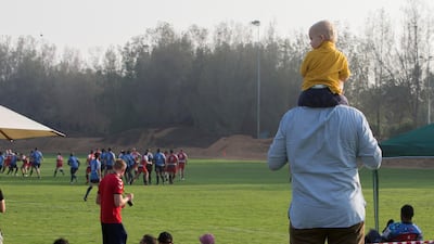 A father and son watch the game from the sidelines