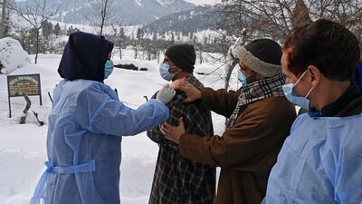 A health worker inoculates a man with a dose of the Covishield vaccine during a vaccination drive in Khag village in Budgam district of Indian-administered Kashmir. AFP