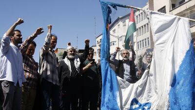 Iranians burn an Israeli flag during a rally marking Al Quds Day in Tehran on Friday. EPA