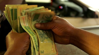 A petrol attendant counts bond notes at a filling station in Harare. REUTERS