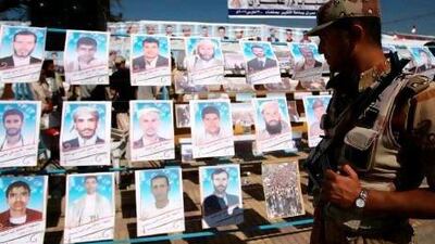 A Yemeni soldier passes posters of anti-government protesters who died last year during a rally against President Ali Abdullah Saleh.