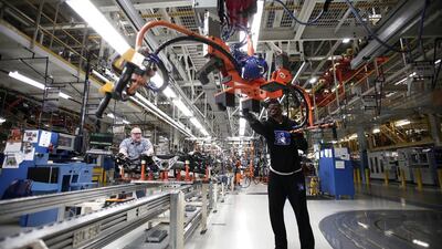 A worker handles a suspension for a 2014 Jeep Cherokee. Bill Pugliano / Getty Images / AFP