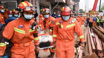Rescuers evacuate a woman pulled alive from a collapsed building in Changsha, in central China's Hunan Province, on May 1. Another woman was rescued more than 132 hours after it collapsed. Xinhua/AP
