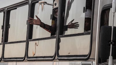 A rescued miner gestures out a bus window carrying some of the hundreds of miners rescued from the Beatrix gold mine shaft number 3 where nearly 1,000 miners were trapped underground following a power outage, in Theunissen, South Africa. Gianluigi Guercia / AFP