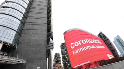 A poster reading "Coronavirus, let's stop it together" is pictured on Piazza Gae Aulenti in Milan. AFP
