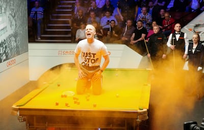 A Just Stop Oil protester threw orange powder on a snooker table during the world championship on Monday. PA